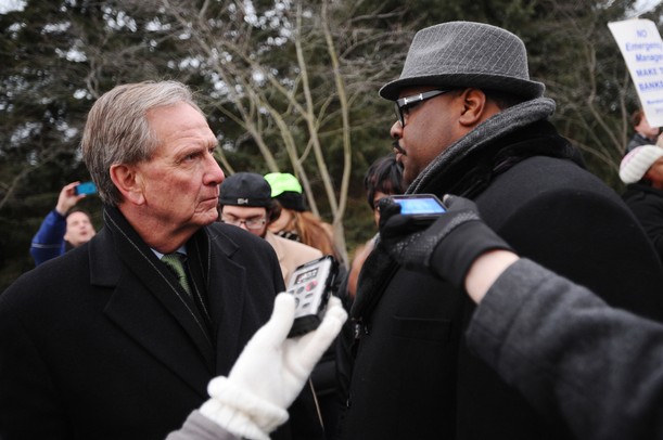 Governor Snyder's chief of staff Dennis Muchmore, left, listens to Rev. Charles Williams II, of Detroit, during a Jan. 16 rally outside of the governor's subdivision in Ann Arbor. Protesters were opposing the state's emergency manager law. Melanie Maxwell I AnnArbor.com